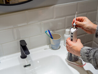 Young man hands changing his domestic dental water flosser tip