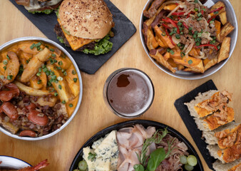 Food on the restaurant table. Top view of different dishes and plates with a wooden background.