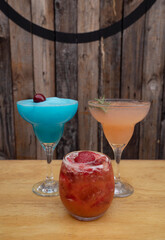 Cocktails. Closeup view of three alcoholic drinks, blue Margarita frozen, pink grapefruit Margarita and a strawberry daiquiri.  