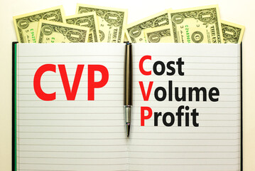 CVP cost volume profit symbol. Concept words CVP cost volume profit on white note on beautiful background from dollar bills. Pen. Business and CVP cost volume profit concept. Copy space.