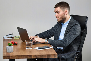 man sitting on chair at table and resting, using laptop