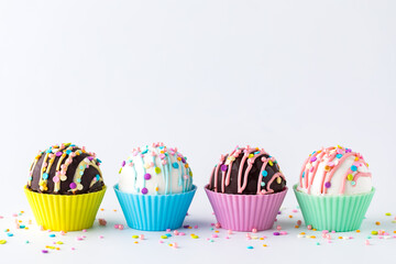 A row of hot chocolate bombs decorated for Easter, against a white background.