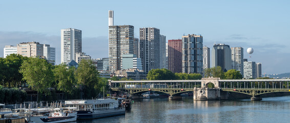 Fototapeta na wymiar River Seine In Paris With Promenade, Anchored Ships, Hot Air Balloon And Modern Office Buildings