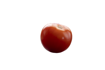 Tomato on a wood cutting board being salted for a meal