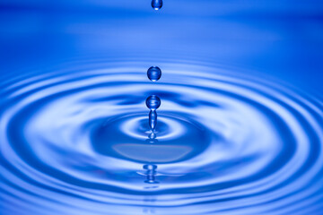 Water droplet falling on water creating a ripple effect