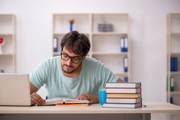 Young male student preparing for exams in the classroom