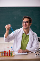 Young male chemist in the classroom