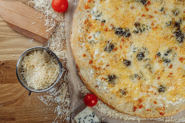 italian four cheeses pizza. Pizza on rustic wooden background with tomato, cheese, basilic. Copy space. Flat lay picture for recipe or menu
