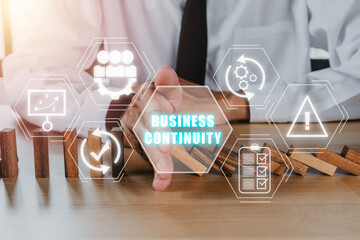 Business continuity concept, Business person hand stopping falling wooden dominoes effect from...