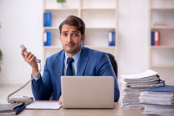 Fototapeta premium Young male employee and too much work in the office