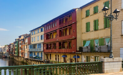Fototapeta na wymiar View from bridge of Castres townscape overlooking old colorful houses along Agout river on sunny summer day, Tarn department France