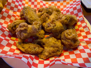 Close up, selective focus on Korean fried chicken in a basket with red checkered paper