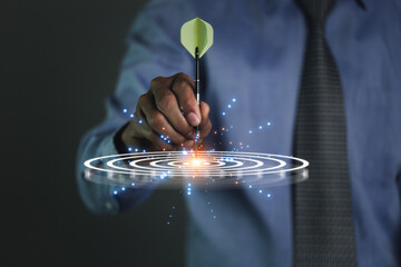 Businessman holding dart to Targeting the business concept.