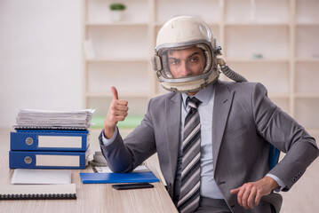 Young male employee wearing spacesuit in the office