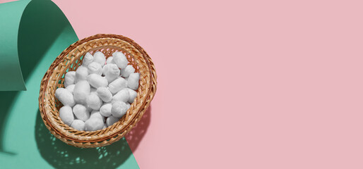 Wicker basket with soft cotton balls on color background with space for text