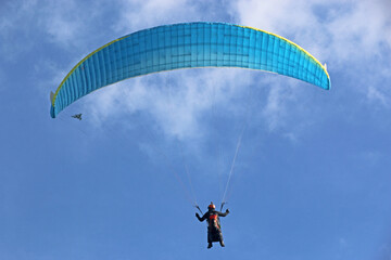 Paraglider flying in a cloudy sky
