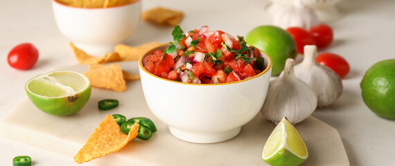 Bowl of tasty Pico de Gallo salsa on light background