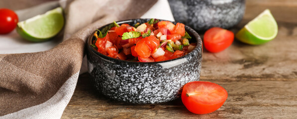 Bowl of tasty Pico de Gallo salsa on wooden table