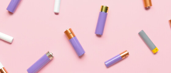 Alkaline batteries on pink background, top view