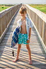 Young Preteen Boy Standing on Sunny Boardwalk Holding Boogie Board