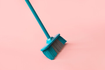 Broom for cleaning on pink background