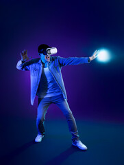 Young man using VR glasses on dark color background