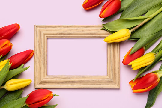 Composition with empty picture frame and beautiful tulip flowers on pink background. Hello spring