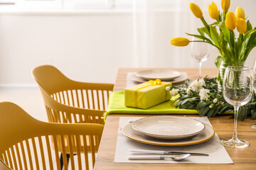 Table setting for International Women's Day celebration with gifts and tulip flowers in light room