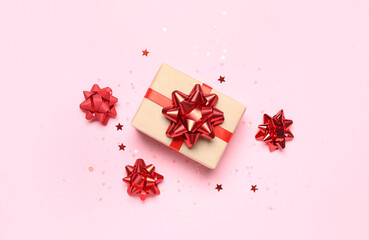 Gift box with red bows and stars on pink background