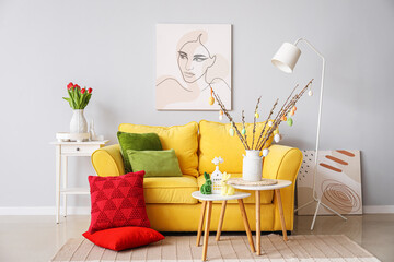 Interior of living room with Easter decor, yellow sofa and tables
