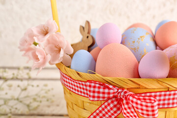 Basket with painted Easter eggs and flowers, closeup