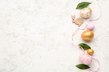Composition with Easter eggs, decor and plant leaves on light background