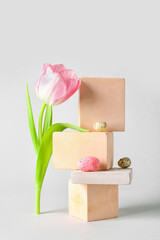 Composition with podiums, tulip flower and Easter eggs on white background