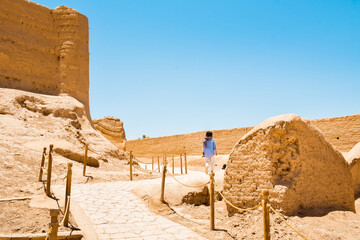 Tourist woman walk in ancient Narin Qal'eh (Qaleh) clay castle in the centre of Meybod near Yazd in...