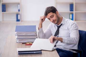 Young male employee and too much work in the office