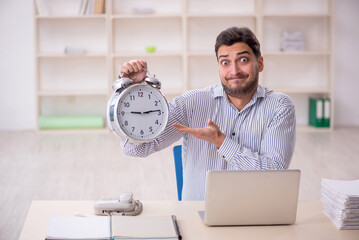 Young male employee in time management concept