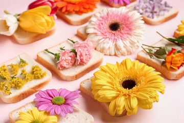 Fototapeta na wymiar Composition with slices of bread and beautiful flowers on pink background, closeup