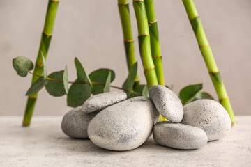 Spa stones, eucalyptus and bamboo on light background