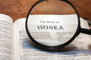 title page book of Hosea close up using magnifying glass in the bible or Torah for faith,...