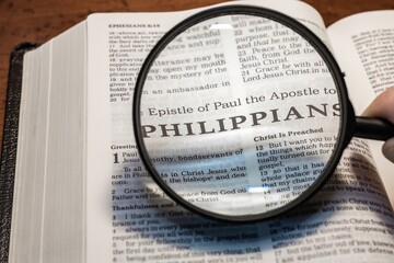title page book of Philippians close up using magnifying glass in the bible for faith, christian,...