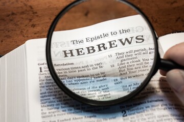 title page book of Hebrews close up using magnifying glass in the bible for faith, christian,...