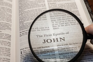 title page book of first John close up using magnifying glass in the bible for faith, christian,...