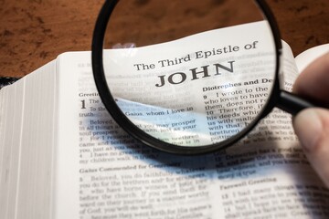 title page book of third John close up using magnifying glass in the bible for faith, christian,...