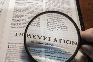 title page book of Revelation close up using magnifying glass in the bible for faith, christian, hebrew, israelite, history, religion, christianity, armageddon