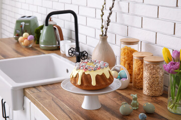 Dessert stand with Easter cake and painted eggs on kitchen counter