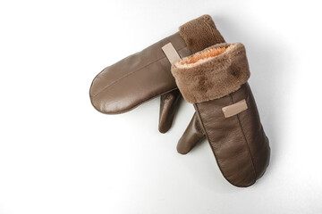 Mittens on a white background. Stylish photo in the studio. Place for text. Fashionable women's mittens in beige. Leather gauntlets
