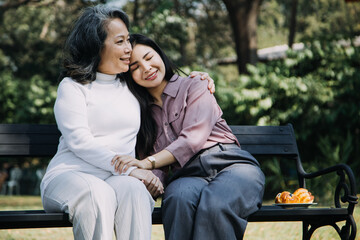 Fototapeta premium Asian young caregiver nurse support senior older male walking outdoors. Specialist girl doctor help and take care of elderly mature man patient doing physical therapy in public park at nursing home.