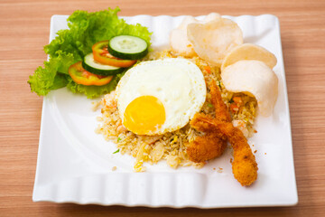 A Plate of seafood fried rice served with a side of shrimp fritters