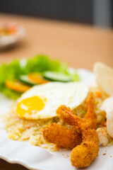 A Plate of seafood fried rice served with a side of shrimp fritters