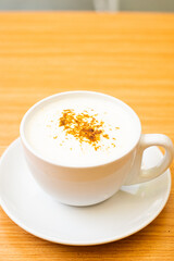 A Glass of cappucino coffee, sprinkled with coffee powder on top of the foam